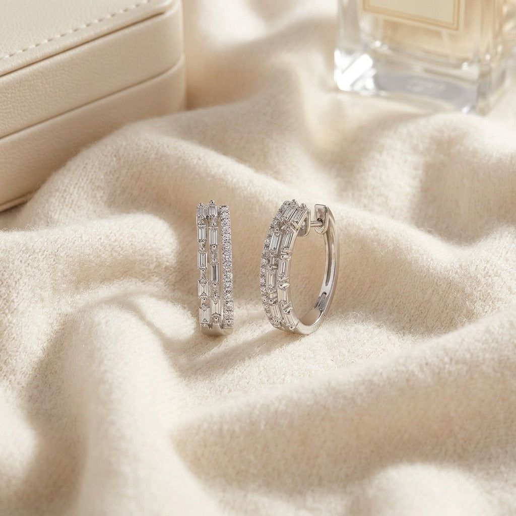Diamond Baguette and Round Brilliant Multi-Row Oval Hinged Hoop Earring in 14k White Gold — textile flat lay