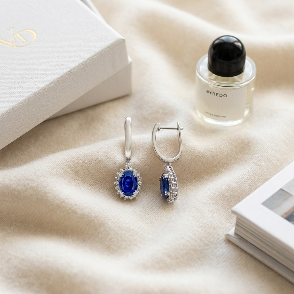 Sapphire Oval and Diamond Starburst Frame Earrings in 14k White Gold (7x5mm) — textile flat lay