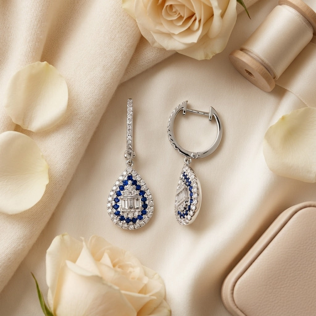 Sapphire and Diamond Pear Shape Dangle Earrings in 14k White Gold — textile flat lay