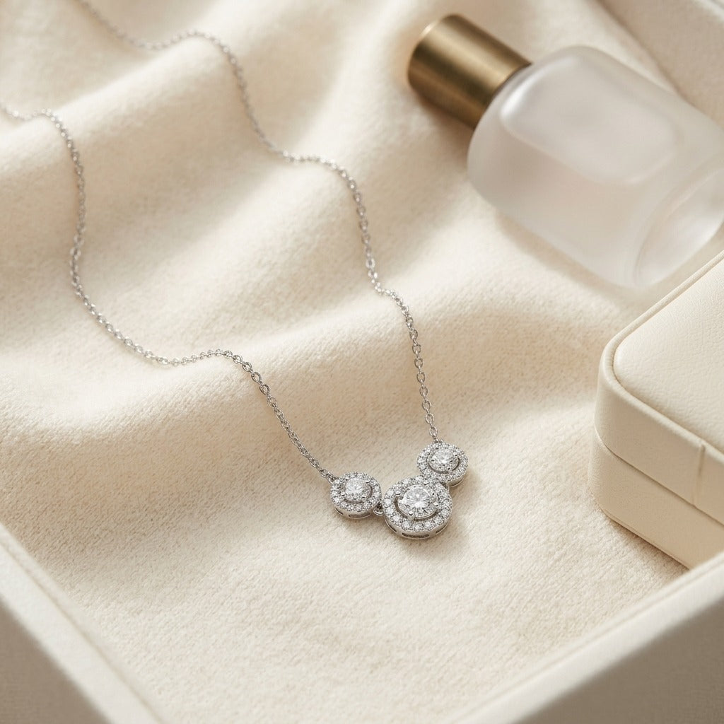 Diamond Three Stone Halo Necklace In 14k White Gold — textile flat lay