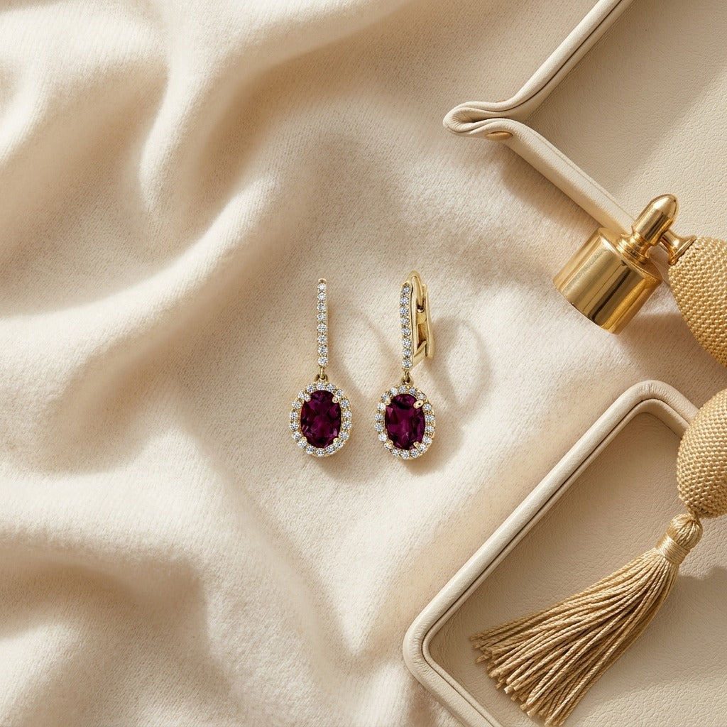 Rhodolite Garnet and Diamond Oval Halo Dangle Earrings with Pave Leverbacks in 14k Yellow Gold (7x5mm) — textile flat lay
