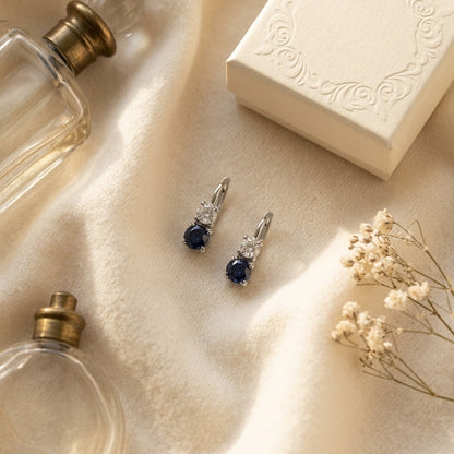 Sapphire And Diamond Two Stone Hinged Back Earrings In 14k White Gold — textile flat lay