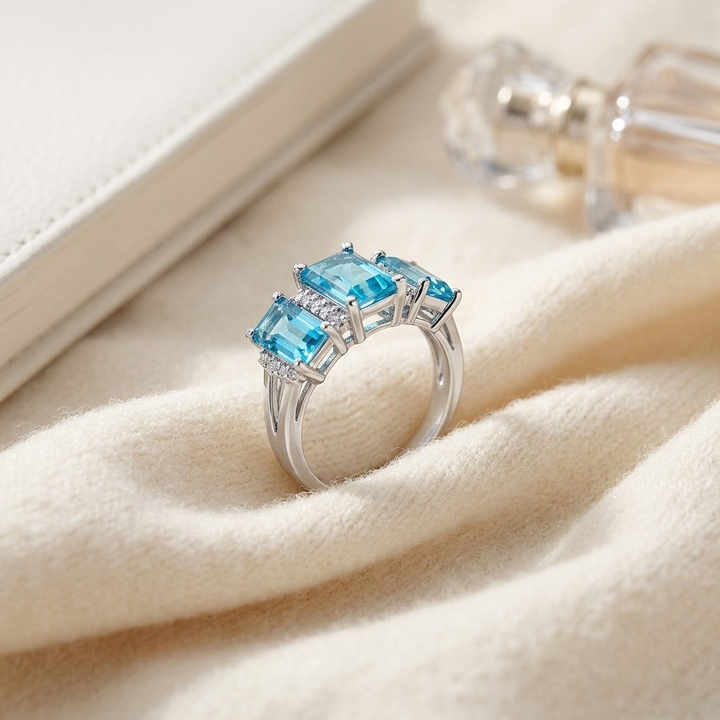 Blue Topaz and Diamond 3 Stone Emerald Cut Ring in 14k White Gold 0.12ctw Hi/Si — textile flat lay