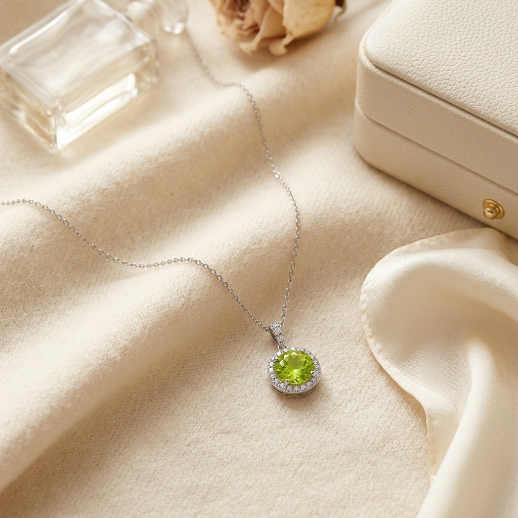 Peridot And Diamond Circle Halo Pendant In 14k White Gold With 18 Inch Baby Curb Chain — textile flat lay