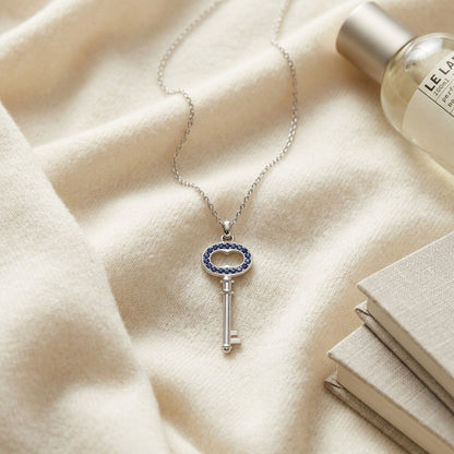 Sapphire Petite Key Pendant in 14k White Gold — textile flat lay