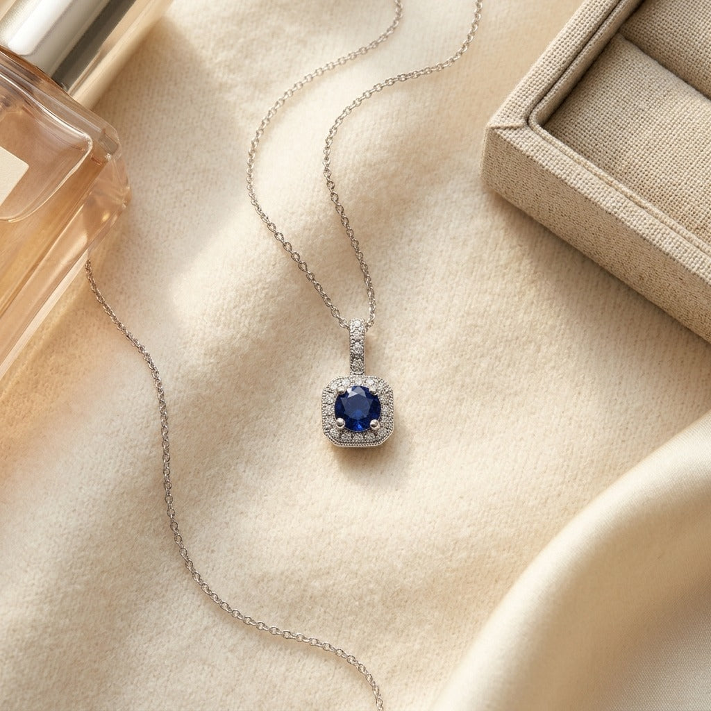 Sapphire and Diamond Halo Pendant in 14k White Gold 17 in Curb Chain — textile flat lay