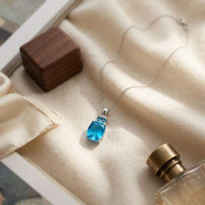 Swiss Blue Topaz And Diamond Pendant With Color-accent Bail In 14k White Gold — textile flat lay
