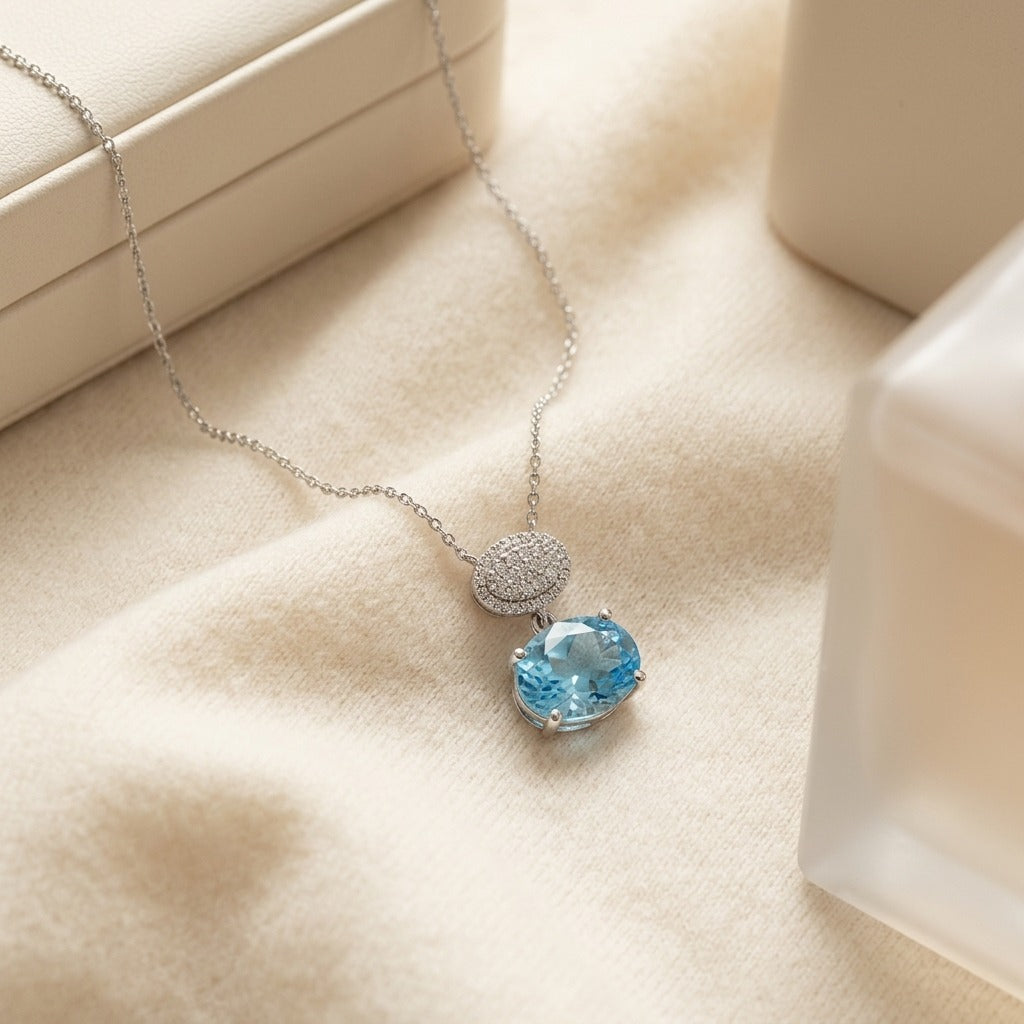 Blue Topaz Oval & Diamond 1/16ctw Pendant Set in 14k White Gold with Chain — textile flat lay
