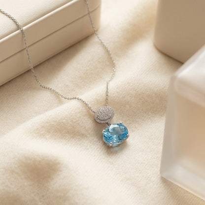 Blue Topaz Oval & Diamond 1/16ctw Pendant Set in 14k White Gold with Chain — textile flat lay