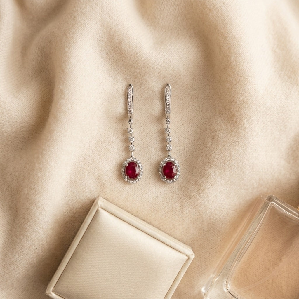 Ruby And Diamond Dangle Oval Halo Earrings In 14k White Gold (6x4mm) — textile flat lay