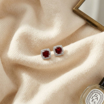 Garnet and Diamond Cushion Halo Earrings in 14k White Gold — textile flat lay