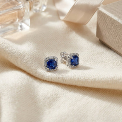 Sapphire and Diamond Cushion Halo Earrings in 14k White Gold — textile flat lay