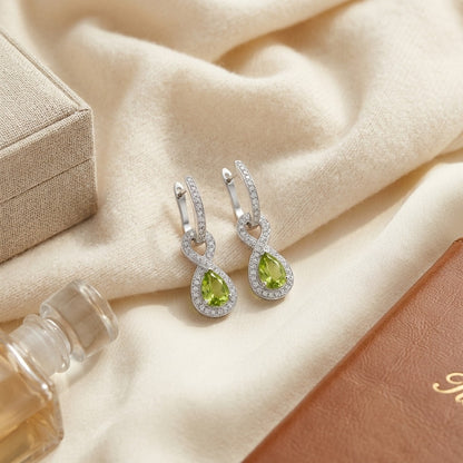 Peridot And Diamond Infinity Dangle Earrings In 14k White Gold — textile flat lay