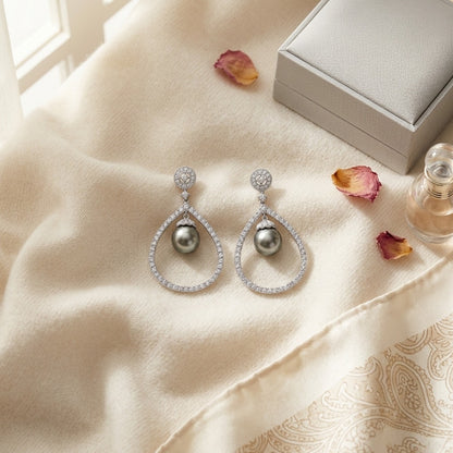 Black Pearl and Diamond Tear Drop Earrings in 14k White Gold — textile flat lay