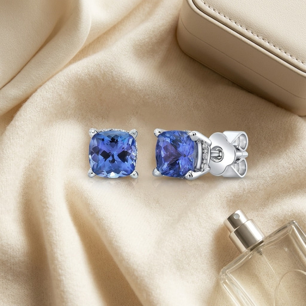 5 Millimeter Cushion Cut Tanzanite 4 Prong Studs in 14k White Gold — textile flat lay
