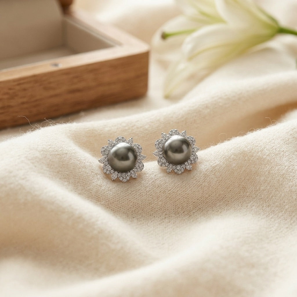 Tahitian Pearl and Diamond Earrings with Arabesque Border in 14k White Gold — textile flat lay