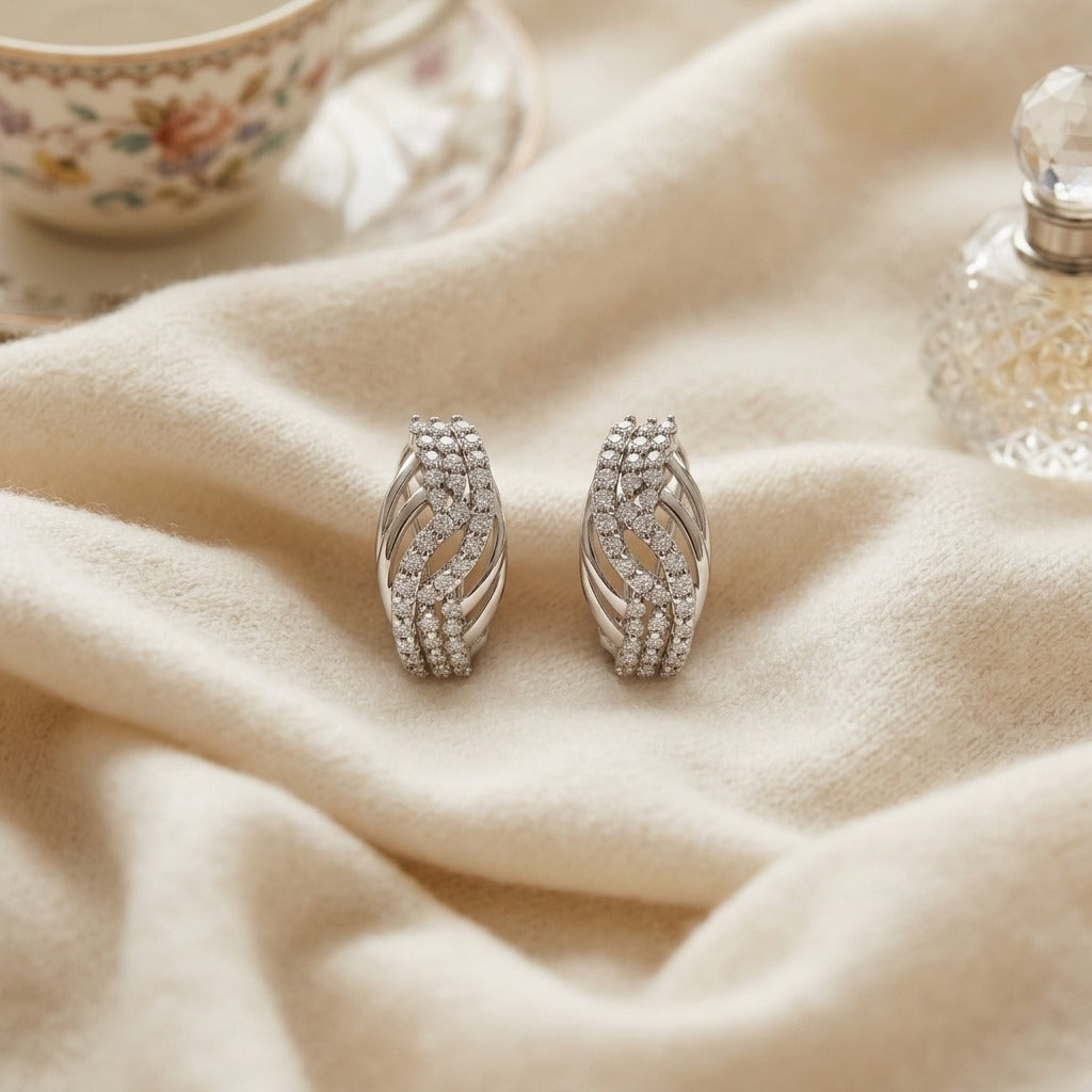 Diamond Weave Omega Back Earrings in 14k White Gold 7/8ctw — textile flat lay