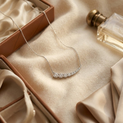 Diamond Round Graduated Prong-Set Comet Necklace in 14k White Gold — textile flat lay