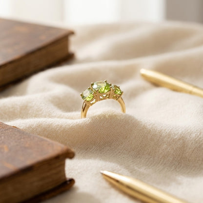 Peridot Oval Three Stone Ring In 14k Yellow Gold — textile flat lay