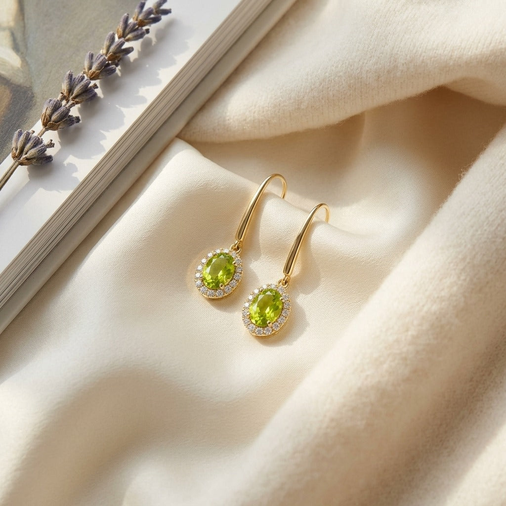 Peridot and Diamond Oval Halo Leverback Earrings in 14k Yellow Gold 1/4ctw — textile flat lay