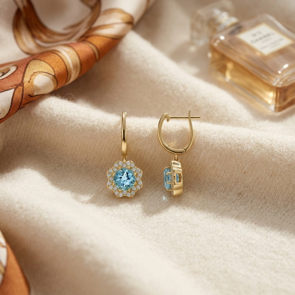 Blue Topaz and Diamond Round Brilliant Earrings in 14k Yellow Gold — textile flat lay