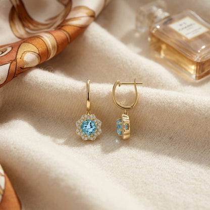 Blue Topaz and Diamond Round Brilliant Earrings in 14k Yellow Gold — textile flat lay
