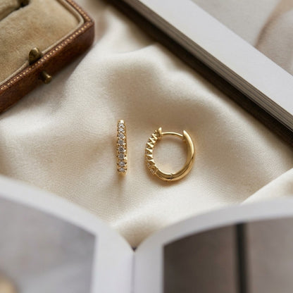 Diamond Oval Hoop Huggie Earrings in 14k Yellow Gold 1/4ctw — textile flat lay