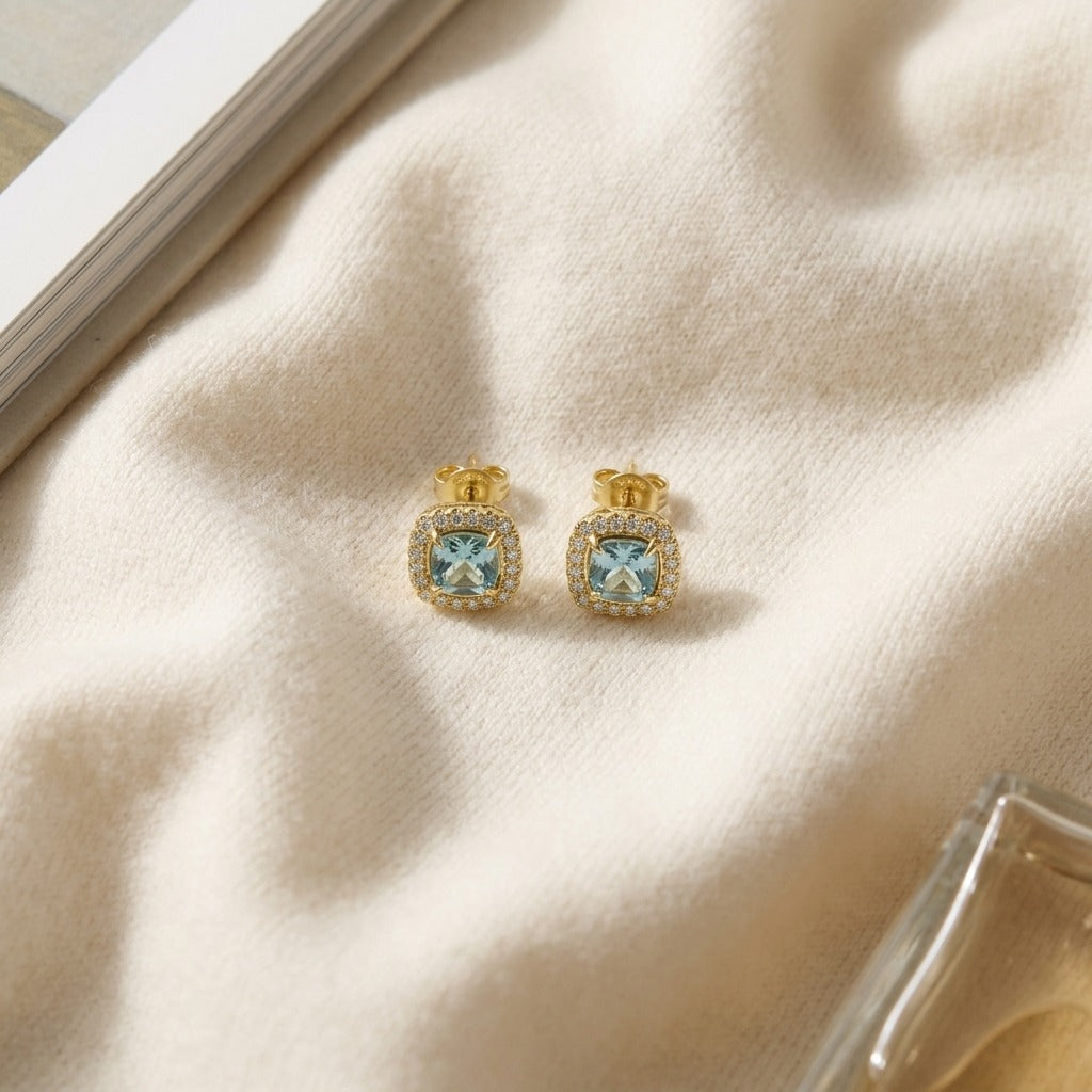 Swiss Blue Topaz Framed in 14k Yellow Gold and Diamond 1/5ctw Earring — textile flat lay