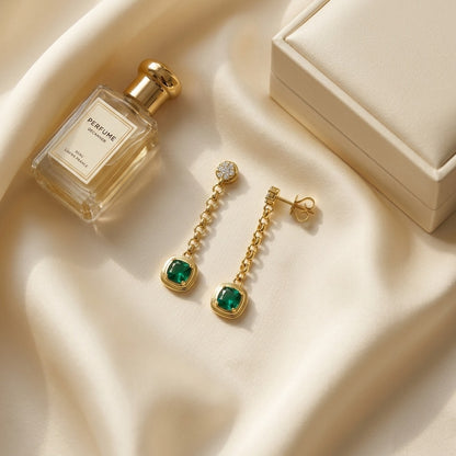 14k Yellow Gold Created Emerald 1.10ctw and Diamond 1/5ctw Chain Drop Earring — textile flat lay