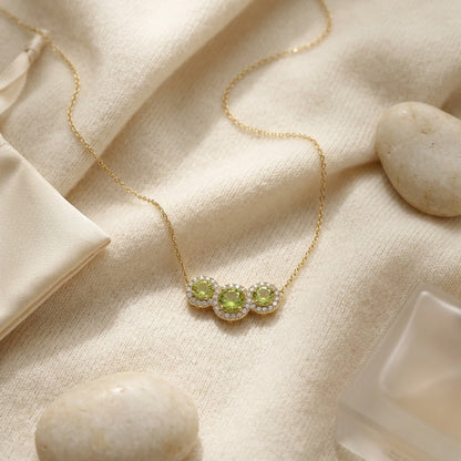 Peridot and Diamond Round Halo Trio Necklace in 14k Yellow Gold — textile flat lay