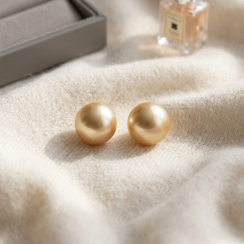 Golden South Sea Pearl Stud Earrings In 14k Yellow Gold (9.5-10mm) — textile flat lay